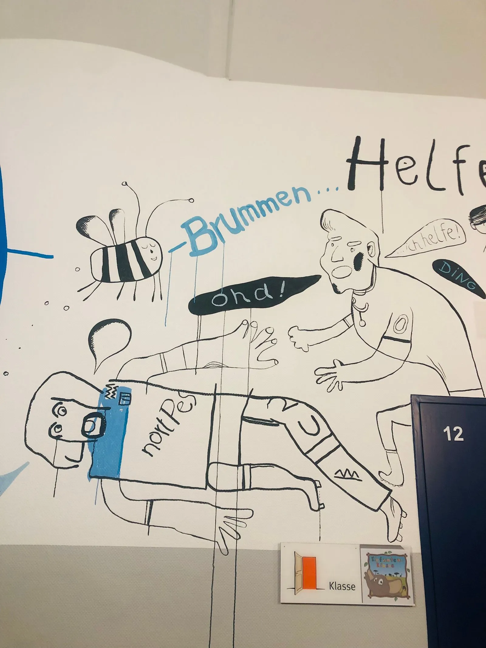 Wandzeichnung mit einer summenden Biene, Comicfiguren, Sprechblasen ("Brummen..."), Türschild "Klasse 12"